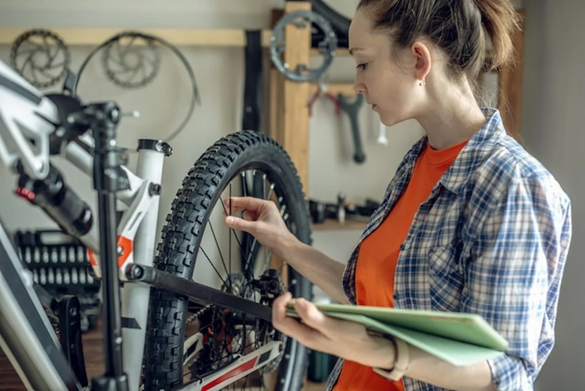 Kobieta wykonuje konserwację roweru górskiego