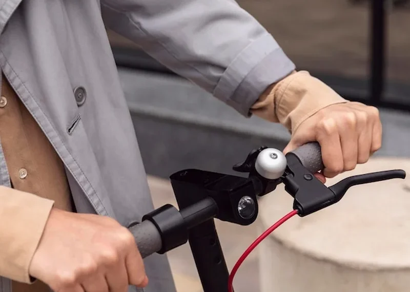 Mężczyzna trzyma skuter elektryczny za uchwyt