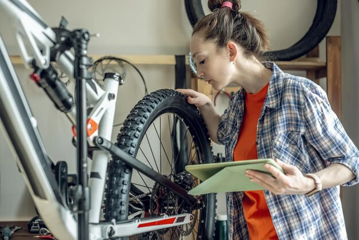 Kobieta wykonuje konserwację roweru górskiego