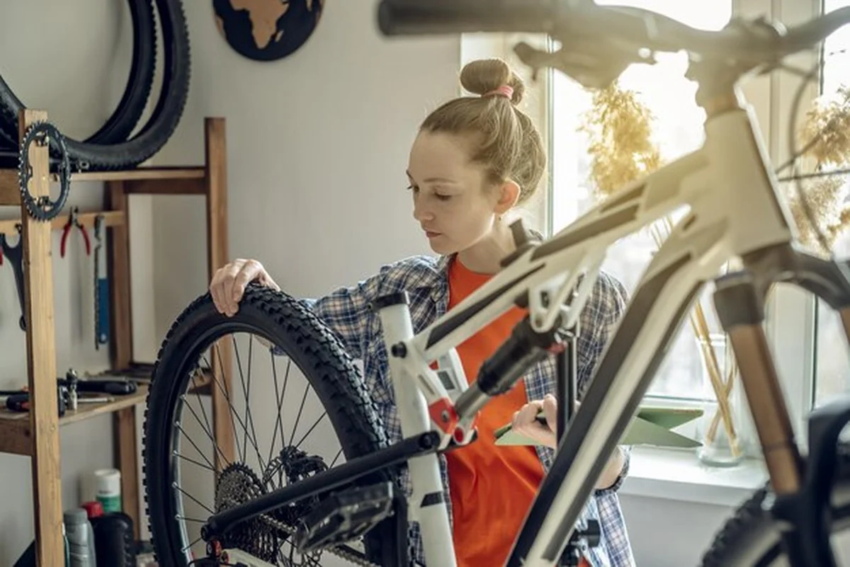 Kobieta naprawia rower górski w warsztacie