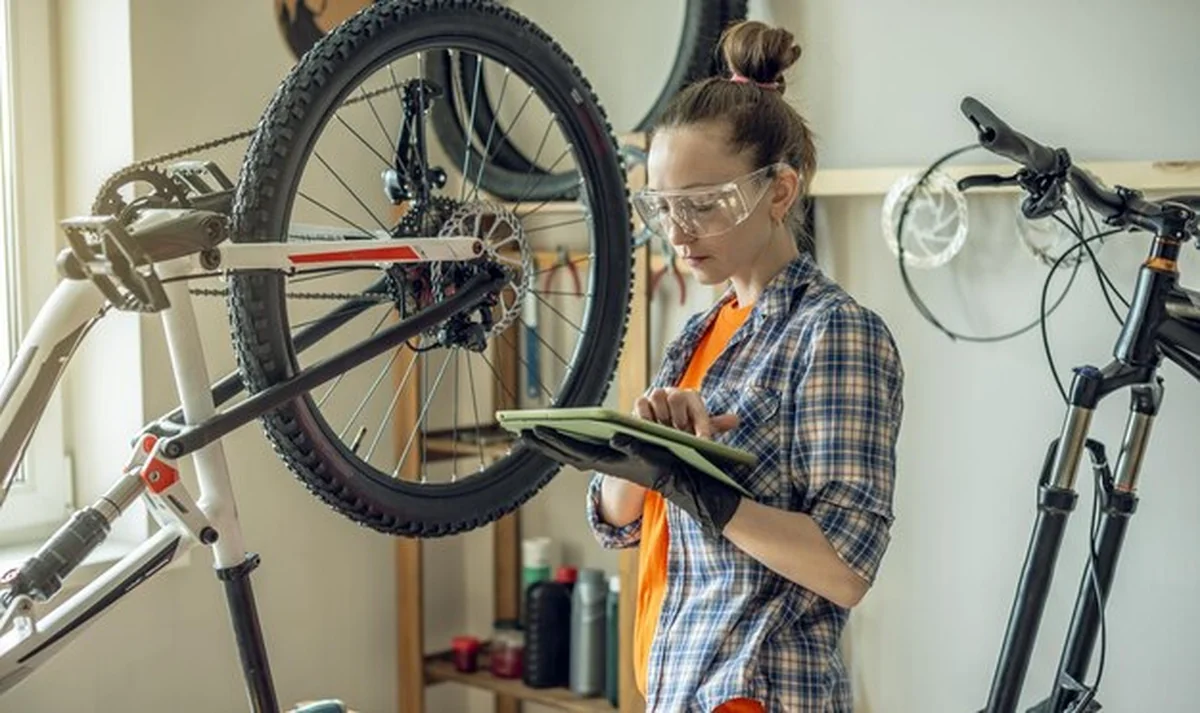 Kobieta naprawiająca rower w warsztacie