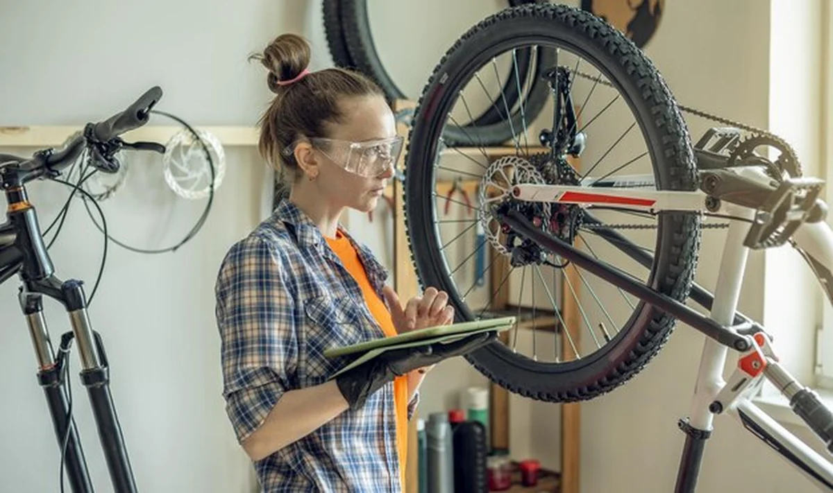Kobieta wykonuje konserwację roweru górskiego