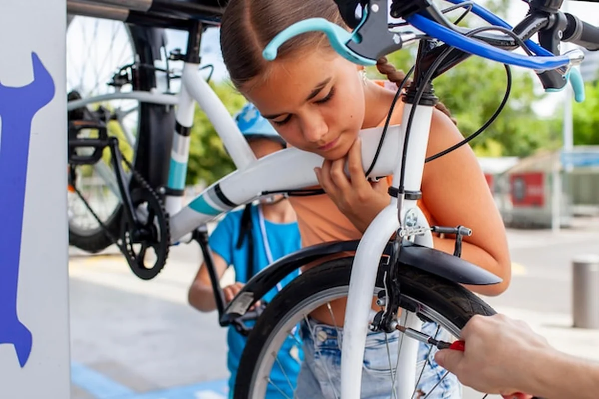 Małe dziecko na rowerze zajęte naprawą i nauką