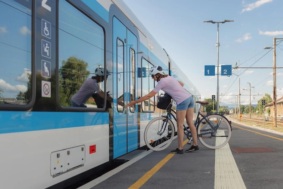 Rowerzysta wsiada do pociągu ze swoim rowerem na stacji